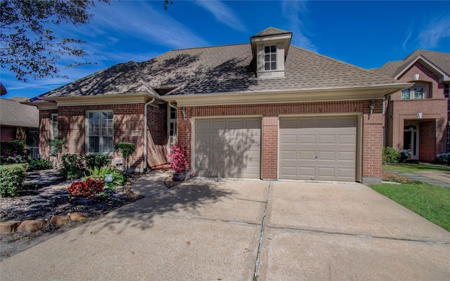 view of front of property with driveway, a shingled roof, an attached garage, and brick siding