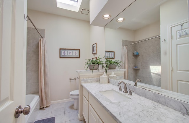 full bathroom featuring toilet, a skylight, vanity, baseboards, and tile patterned floors