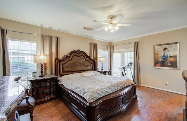 bedroom featuring multiple windows, wood finished floors, and crown molding