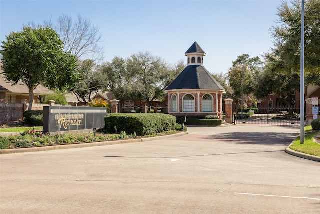 view of street featuring curbs, a gated entry, and a gate