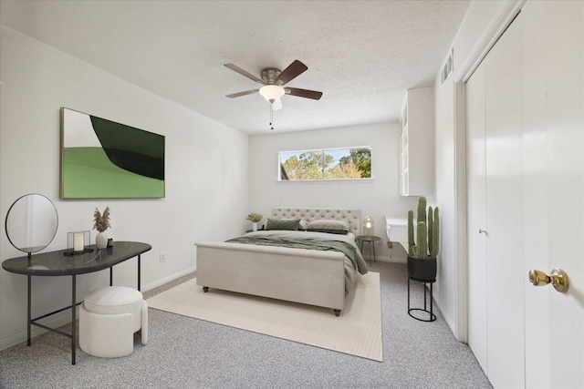 carpeted bedroom with visible vents, baseboards, a ceiling fan, a textured ceiling, and a closet