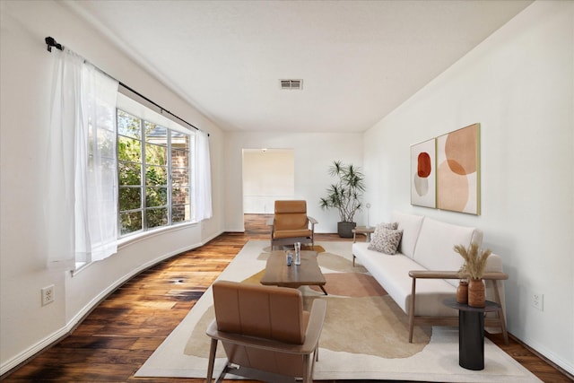 living area featuring wood finished floors, visible vents, and baseboards