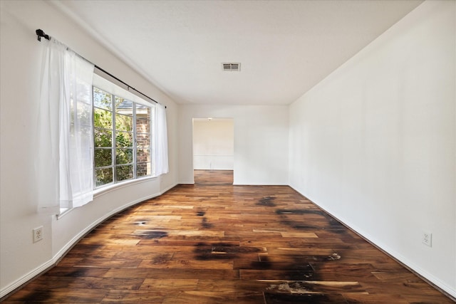 unfurnished room with wood finished floors and visible vents