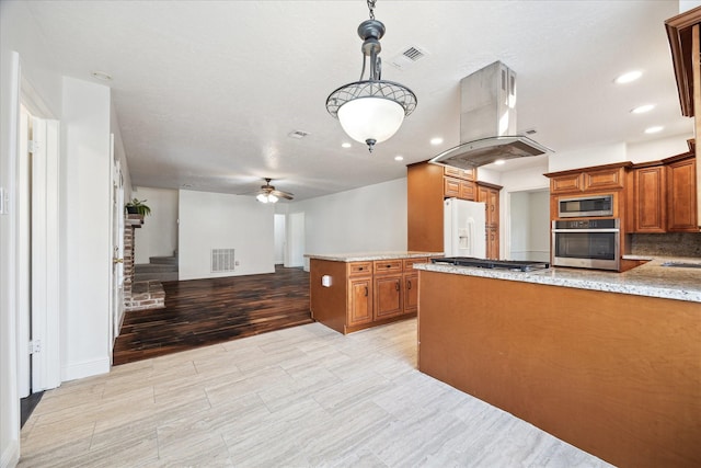 kitchen featuring appliances with stainless steel finishes, brown cabinets, island exhaust hood, and visible vents