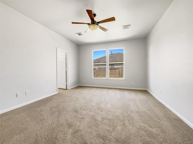 empty room with visible vents, a ceiling fan, baseboards, and carpet floors