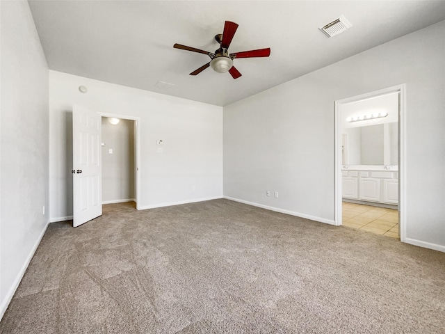 unfurnished bedroom with visible vents, baseboards, ceiling fan, light colored carpet, and connected bathroom