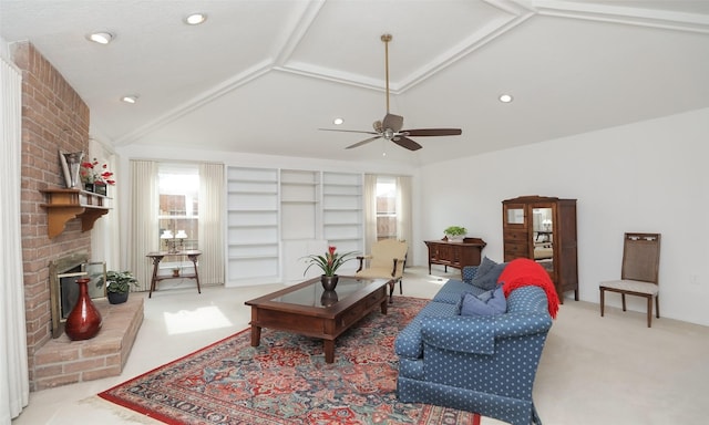 living area featuring vaulted ceiling, carpet floors, ceiling fan, and a fireplace