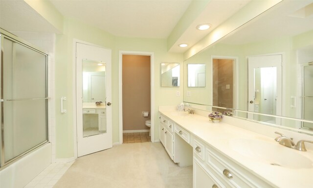 full bathroom featuring toilet, double vanity, a sink, and recessed lighting