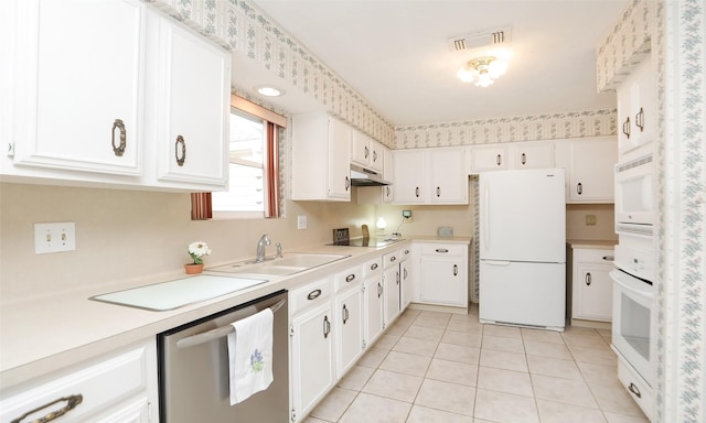 kitchen featuring light countertops, visible vents, a sink, white appliances, and under cabinet range hood