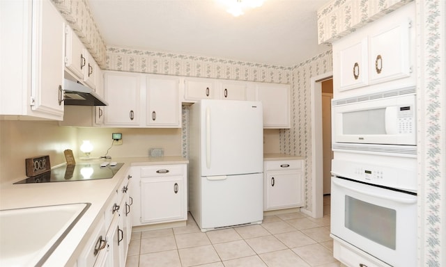 kitchen featuring white appliances, wallpapered walls, white cabinets, light countertops, and under cabinet range hood