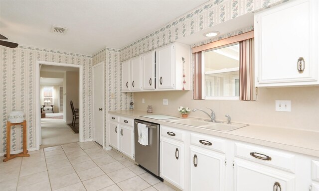 kitchen featuring white cabinets, dishwasher, a sink, and wallpapered walls