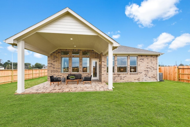 back of property with a shingled roof, a lawn, a fenced backyard, a patio area, and brick siding