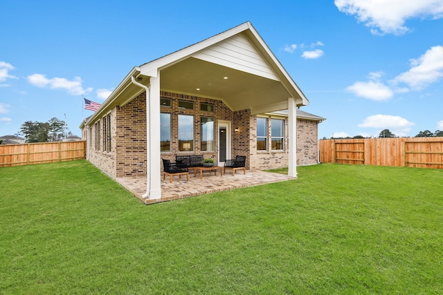 back of house featuring brick siding, a lawn, a patio area, and a fenced backyard