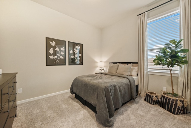 bedroom featuring light colored carpet and baseboards