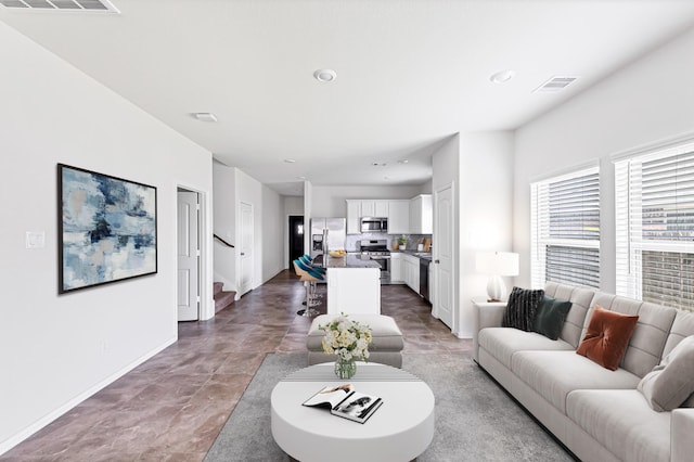 living room featuring visible vents, stairway, baseboards, and recessed lighting