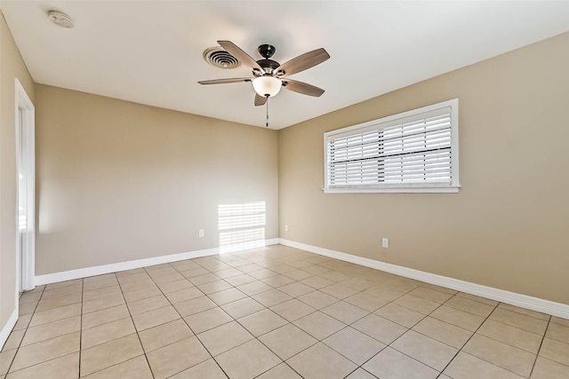 spare room with a ceiling fan, visible vents, and baseboards