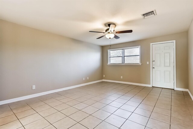 spare room with light tile patterned floors, ceiling fan, visible vents, and baseboards