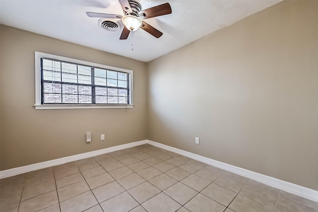 empty room featuring light tile patterned floors, ceiling fan, visible vents, and baseboards