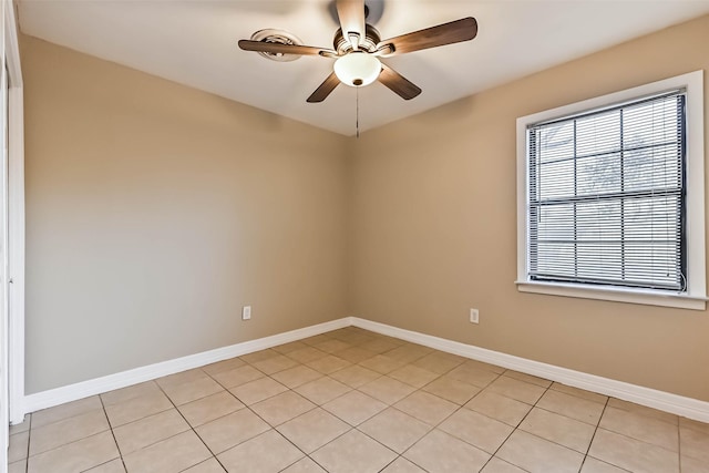 spare room with light tile patterned floors, baseboards, and a ceiling fan