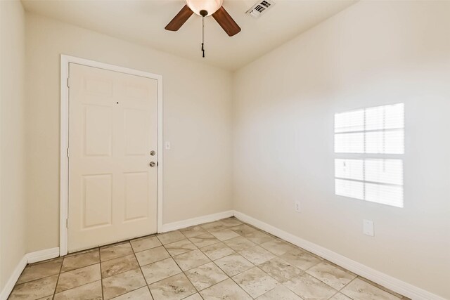 spare room featuring ceiling fan, visible vents, and baseboards