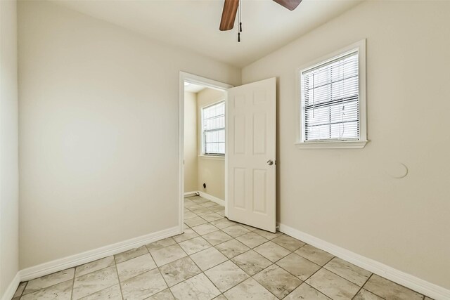 unfurnished room featuring light tile patterned floors, a ceiling fan, and baseboards