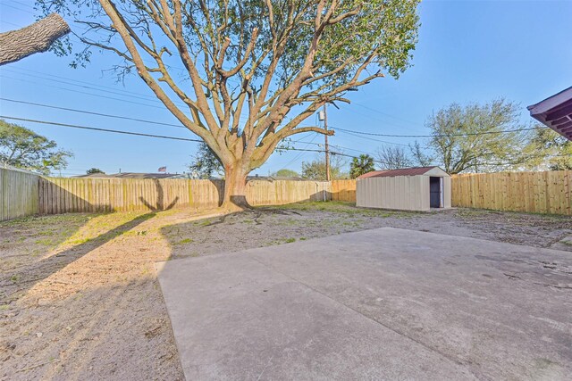 view of yard with a patio, a shed, an outdoor structure, and a fenced backyard