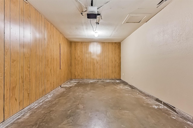 unfurnished room featuring wooden walls and unfinished concrete floors