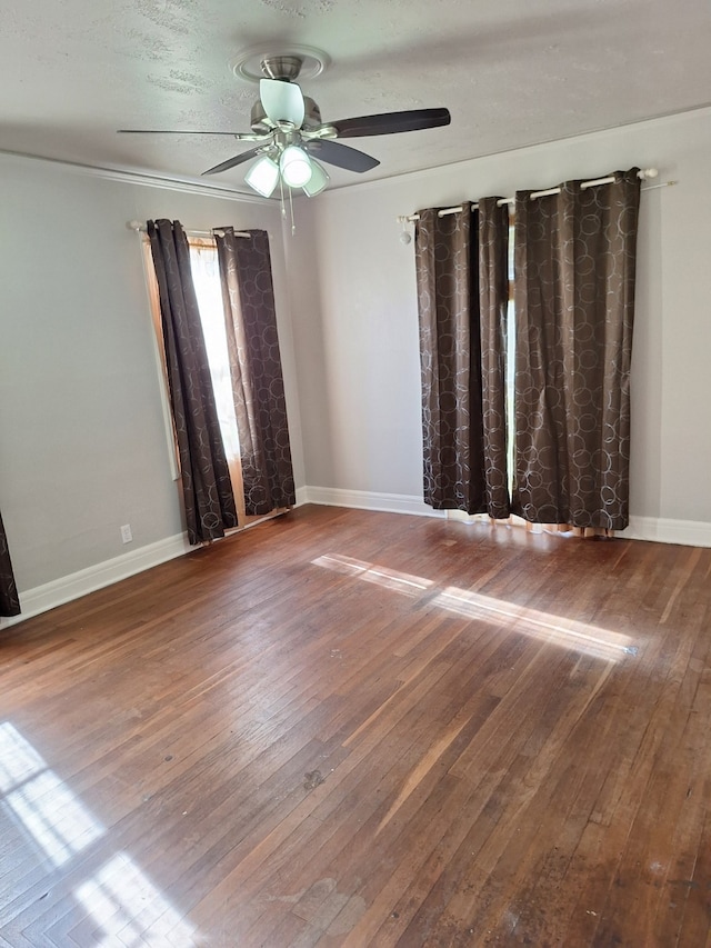 unfurnished room featuring hardwood / wood-style floors, baseboards, and ceiling fan