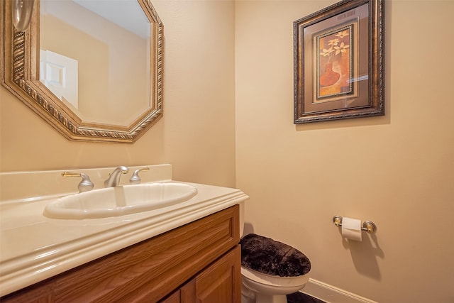 half bathroom featuring toilet and vanity