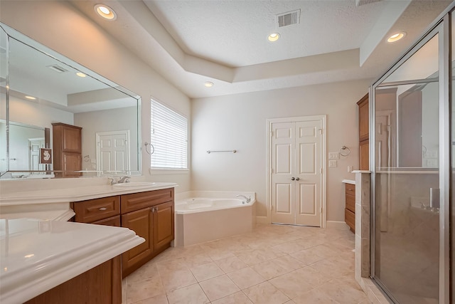 full bath with tile patterned floors, visible vents, a garden tub, a tray ceiling, and vanity