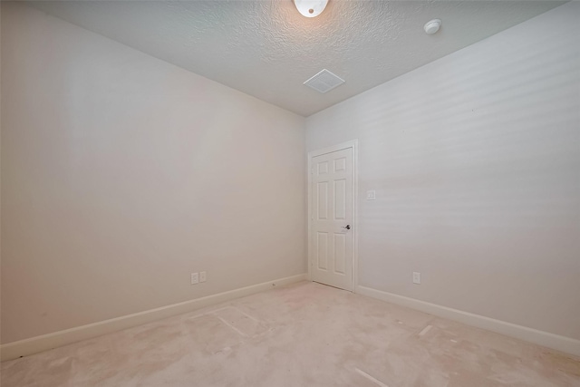 unfurnished room featuring light carpet, baseboards, and a textured ceiling