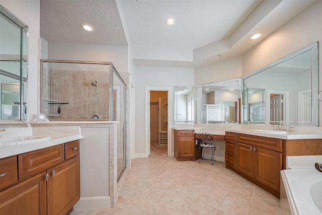 full bath featuring a sink, two vanities, and a stall shower