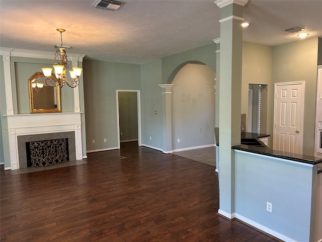 unfurnished living room featuring dark wood-style flooring, a high end fireplace, visible vents, and baseboards