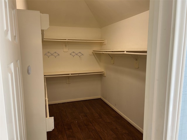 spacious closet with dark wood-style floors and lofted ceiling