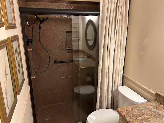 full bathroom with toilet, a stall shower, and vanity