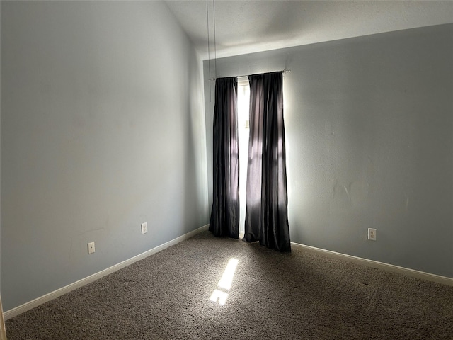 carpeted spare room featuring baseboards