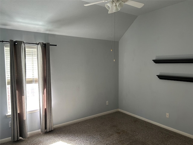 empty room featuring vaulted ceiling, carpet, a ceiling fan, and baseboards