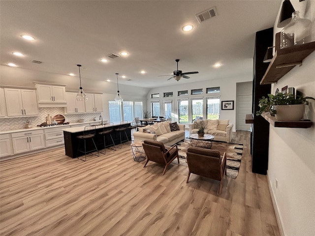 living area featuring ceiling fan, light wood-style flooring, recessed lighting, visible vents, and baseboards