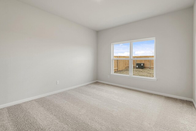 spare room featuring carpet flooring and baseboards