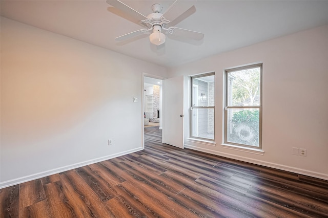 spare room with dark wood-type flooring, baseboards, and ceiling fan