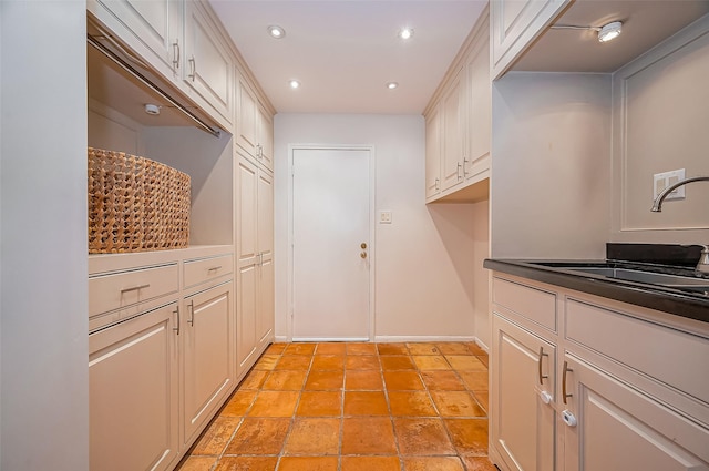 kitchen featuring a sink, baseboards, and recessed lighting