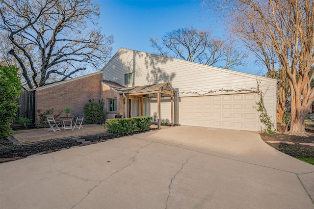 view of front of property featuring a garage, brick siding, and driveway