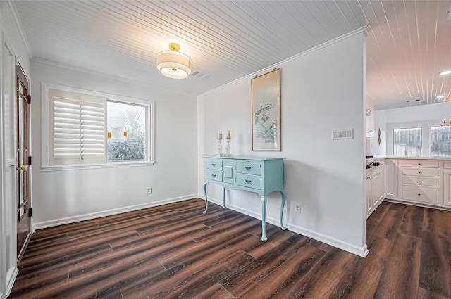 interior space with visible vents, dark wood-type flooring, baseboards, and ornamental molding