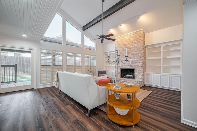 living area featuring dark wood-style floors, a healthy amount of sunlight, and a brick fireplace