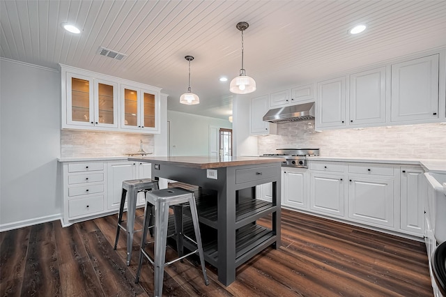 kitchen with under cabinet range hood, visible vents, dark wood-style flooring, and white cabinetry