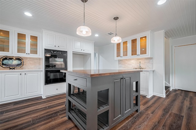 kitchen with white cabinetry, dark wood finished floors, backsplash, and dobule oven black