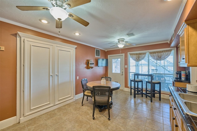 dining room featuring visible vents, a textured ceiling, crown molding, and baseboards