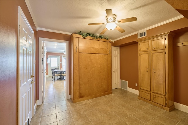 unfurnished bedroom featuring a textured ceiling, baseboards, visible vents, and ornamental molding