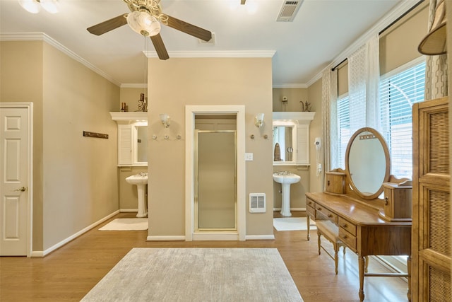 sitting room with wood finished floors, visible vents, and ornamental molding