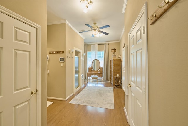 entryway with baseboards, light wood-style floors, ceiling fan, and crown molding